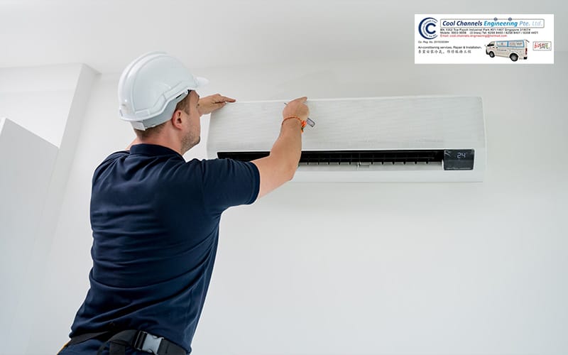 Technician installing an aircon unit in a wall.