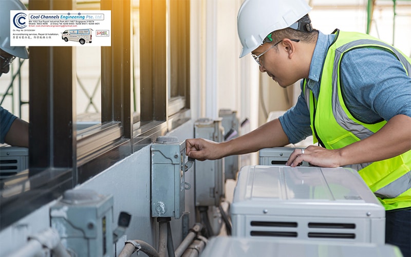 Technician fixing air conditioner unit on outside wall.